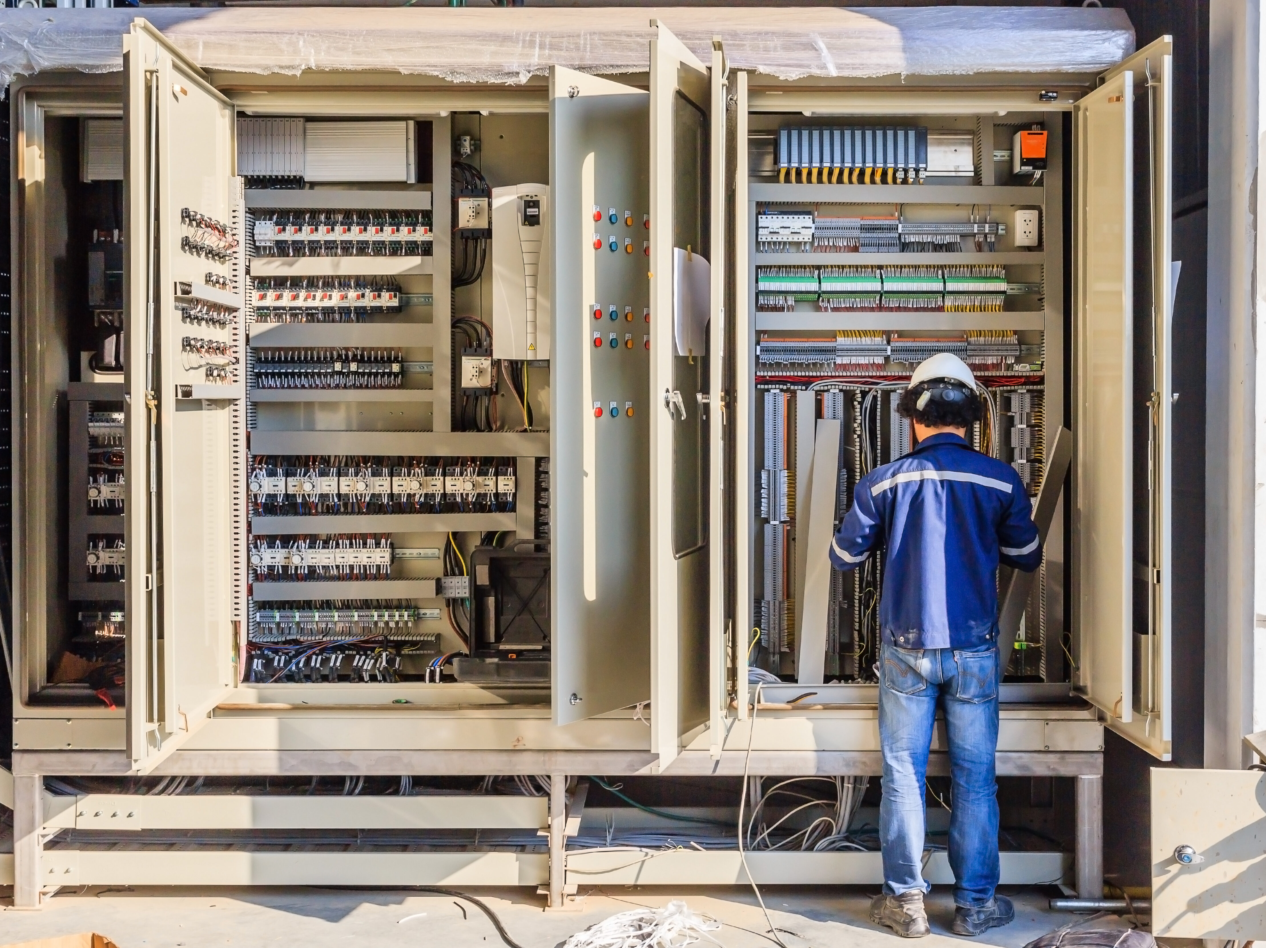 Instrument technician on the job check wiring on PLC cabinet